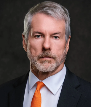 The image shows a professional headshot of a distinguished older man with gray hair and a gray beard, wearing a dark suit and orange tie, likely Michael Saylor, the MicroStrategy CEO known for his massive Bitcoin acquisitions. The photo accompanies a post highlighting concerns about Saylor's leveraged Bitcoin strategy, noting BTC's drop from his $75,000 average purchase price to $62,000, along with signs of selling pressure from his STRC preferred stock and persistent ETF outflows.