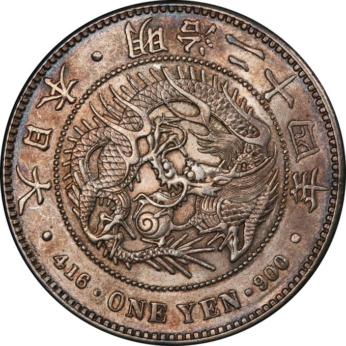 Close-up of an antique Japanese silver coin featuring a dragon design, marked '416 ONE YEN 900', indicating its silver purity.