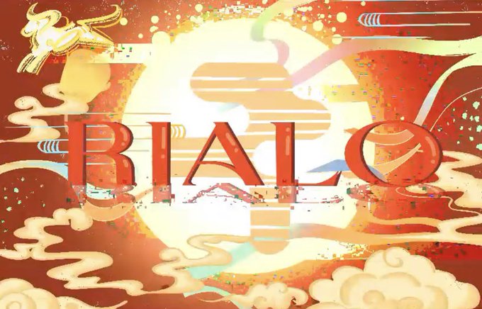 The image features an illustration of a large, colorful sun with clouds surrounding it. Beneath the sun, there are words written in red that say "Rialo", which appears to be a reference to the artist's name or the title of their work. The background is filled with various colors and shapes, creating a vibrant and dynamic atmosphere.
