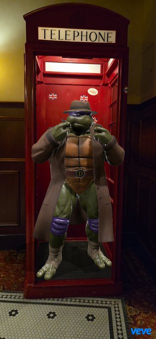 A digital artwork from Veve showing a Teenage Mutant Ninja Turtle wearing a trench coat and fedora hat standing inside a red British telephone booth.