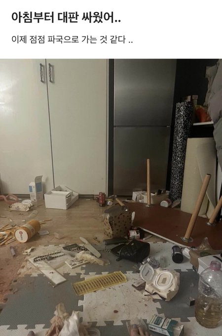 A messy room strewn with debris, an overturned table, and scattered household items, captioned in Korean "아침부터 대란 싸웠어.. 이제 점점 파국으로 가는 것 같다 .." (which translates to "Fought a big mess since morning.. It feels like things are going toward catastrophe.."), paired with a post about Bitcoin ("비트코인 샀네") — humorously suggesting the chaos mirrors a crypto market crash.