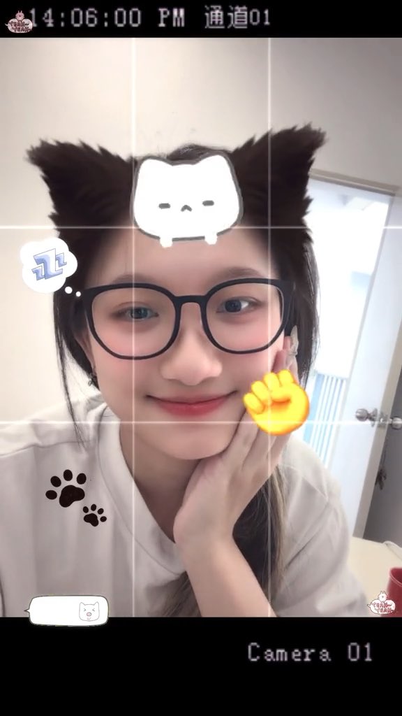 A young woman with glasses poses for a selfie adorned with cute filter stickers (cat ears, a fist emoji, and paw prints), with a timestamp of "14:06:00 PM 通道01" at the top and "Camera 01" at the bottom. The image accompanies a lighthearted post promoting the Jup Mobile app, where she shares a referral code "JOEYJOEY" for cashback perks, playfully tying her good mood to her fresh manicure.