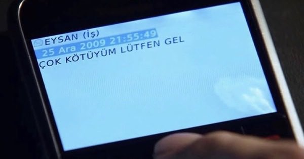 The image shows a cell phone screen displaying text written in Turkish, with the person's finger pointing at the screen. The text appears to be related to an email or message from someone named EYSAAN (Eyewitness) who has sent them a message via Airdrop.