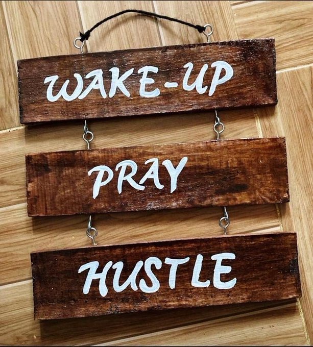 A wooden hanging sign made of three slats reads 'WAKE-UP', 'PRAY', and 'HUSTLE' in white lettering.
