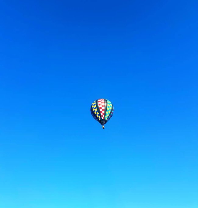 A colorful hot-air balloon floating in a clear blue sky.