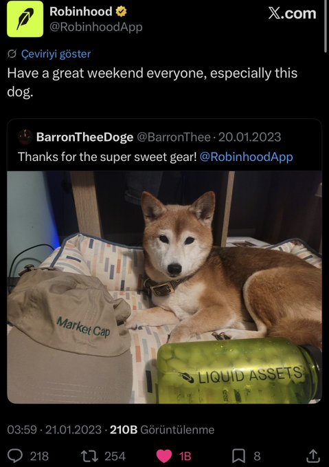 Robinhood's official account (@RobinhoodApp) tweeted "Have a great weekend everyone, especially this dog," featuring a photo of a Shiba Inu named BarronTheeDog (@BarronThee) posing with Robinhood-branded merchandise labeled "Market Cap" and "Liquid Assets," posted on 20.01.2023 with 210B views.