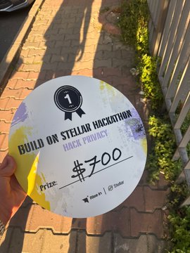 A man is holding up a circular sign with text that reads, "Build On Stellar Hackathon's result thankss! @StellarOrg @risein web 3 @BuildOnStellar". The sign includes two prices listed on separate parts of the circle - $500 and $700. The image also features a person holding the sign on a sidewalk next to a fence or railing, possibly indicating a photo session for an event like this.
