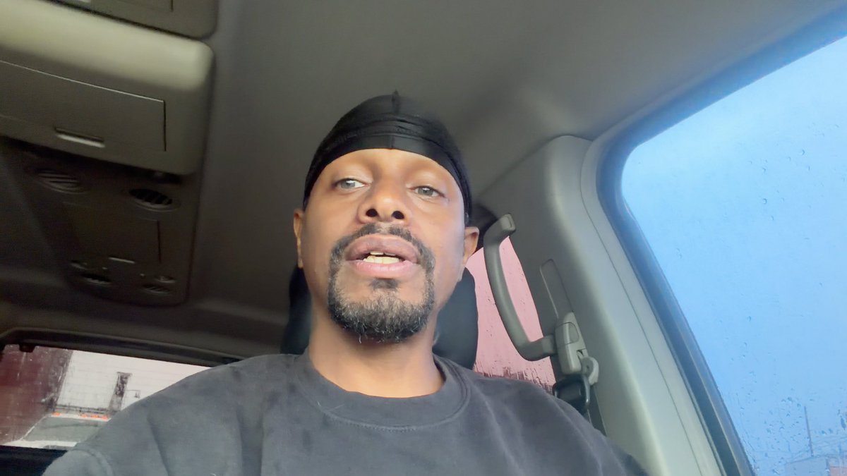 A man wearing a black durag and dark shirt sits inside a vehicle, speaking directly to the camera while seated near the driver's area, likely recording a vlog or video message about the @Kimji_fun platform, the @ImPushingSOL airdrop list, and the $ANSEM token airdrop mentioned in the caption.