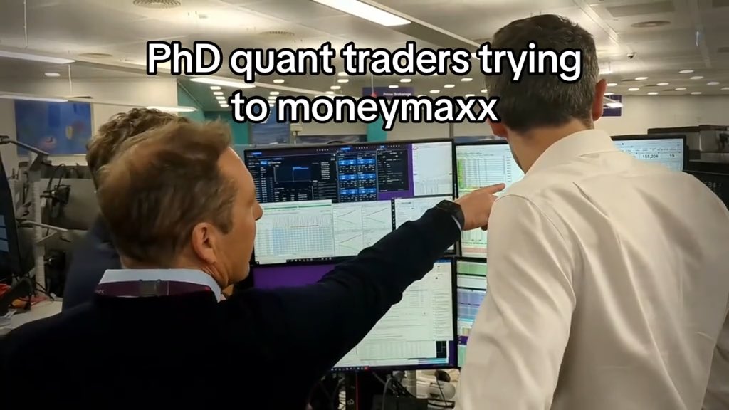 A meme captioned 'PhD quant traders trying to moneymaxx' shows two men in business attire pointing at trading screens displaying financial data and charts.