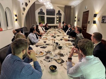 The image shows a group of people gathered around a large dining table in an elegant room for what appears to be a dinner meeting. The caption likely ties in with the post's theme of networking and discussion within the crypto/stablecoin space, suggesting this gathering relates to conversations about stablecoins and real-world assets (RWA) traction in the industry.
