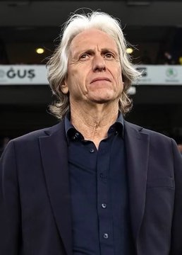A gray-haired man in a dark blazer stands on the sidelines, with the quote attributed to him about reflecting on football and his decisions after a match.