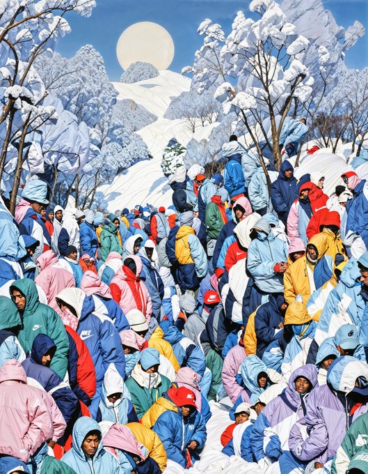 An artistic illustration depicting a large crowd of people wearing colorful hooded jackets (red, blue, pink, yellow, white) gathered in a snowy mountain landscape with a large moon in the sky.