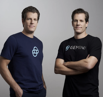 Two men, presumably the Winklevoss twins, pose side-by-side, with the right figure wearing a black shirt displaying the "GEMINI" logo alongside the other in a navy shirt featuring a stylized emblem. The image directly illustrates the post's discussion about the Winklevoss brothers' $WINK (Zcash) ETF filing, tying their public identity as Gemini founders to the cautionary note about not assuming the filing will reverse existing ETF outflows.