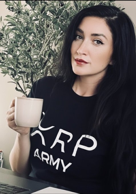 The image features a woman wearing a black t-shirt with white text that says "RP Army" while holding a coffee cup. The background of the photo shows a plant, suggesting an indoor setting like a home or office.