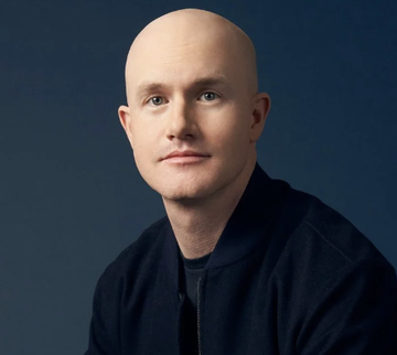 A bald man in a dark navy jacket poses for a professional headshot against a deep blue background. The image likely depicts Coinbase CEO Brian Armstrong, who recently commented on cryptocurrency regulatory clarity following a failed vote, expressing confidence that the SEC and CFTC will move forward with creating clear crypto rules despite political opposition.