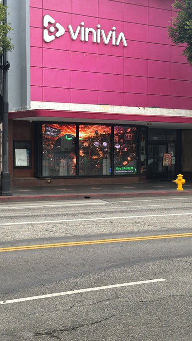 A billboard in a storefront window advertises "$ANSEM" and "RETURN TO MEMES." This is the 90th billboard placed globally, dedicated to $ANSEM.
