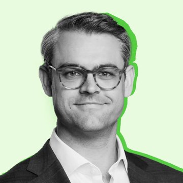 A black and white portrait photograph of a smiling man with glasses, set against a pale green background with a bright green graphic accent.