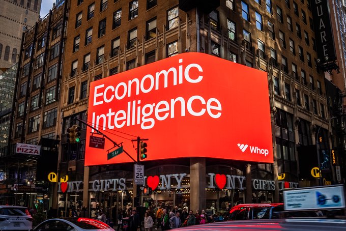 A bright red billboard in a busy city intersection displays "Economic Intelligence" with the "Whop" logo, with the post noting that token input should equal economic output on 9/30. The image visually reinforces the theme by pairing the words "Economic Intelligence" with the date, symbolizing the convergence of AI tokens and economic value.