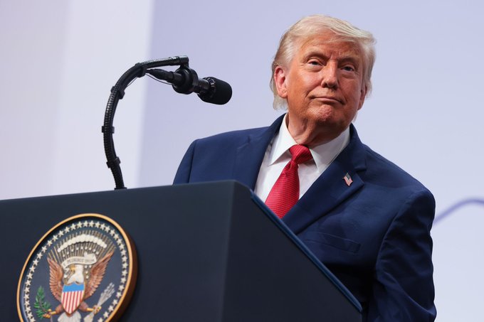 Donald Trump speaks at a podium bearing the Great Seal of the United States. This image supports the statement that Trump emphasized the US must not fall behind China in the cryptocurrency sector.