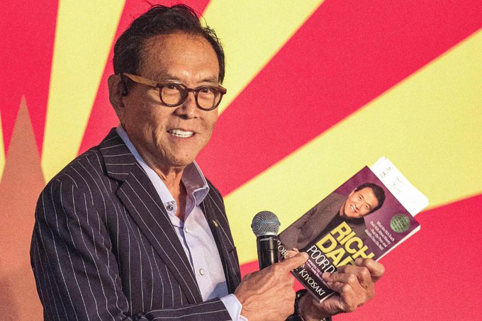 Actor Robert Kiyoshi Ito smiling while holding a microphone and a book titled 'I Am A Big Dave Fan,' with 'Ki-yoshi' printed on the cover.