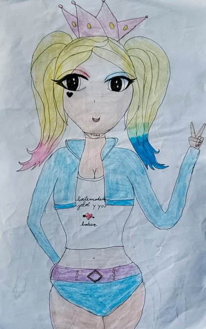 The image features a drawing of a girl wearing a crown, which is colored pastel pink with gold accents. The girl has blonde hair styled into pigtails and is wearing a blue shirt that says "I love you" written on it. She also has a belt around her waist. The drawing appears to be made on paper or parchment, as indicated by the text in the image.