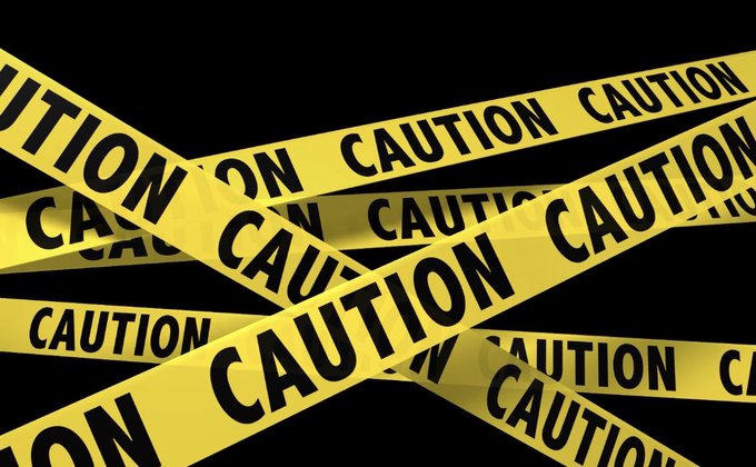 Yellow "CAUTION" tape crisscrosses a black background, visually echoing the post's warning about the crypto market's volatile phase with intense long-short liquidations ("double kills") and Bitcoin's precarious oscillation between $64,000 and $67,000.