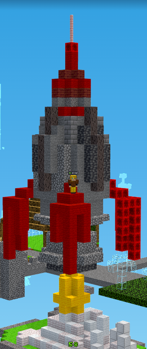 A Minecraft screenshot showing a large tower made of stone and red blocks with yellow accents, featuring a player character and other structures in the background.