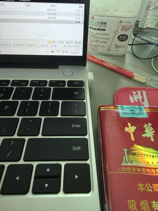 A desk scene featuring a Huawei laptop displaying financial data (stock prices around 4362.99), a bottle of Japanese digestive medicine 'スクラート胃腸薬', eyeglasses, a red pen, and a red Chinese tobacco package with '中華' (Zhonghua) branding featuring Tiananmen Square.