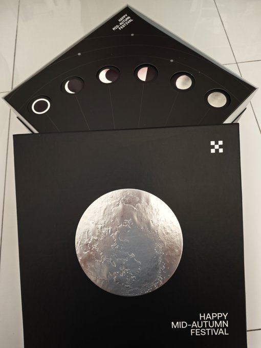 A black Mid-Autumn Festival greeting card displays the moon phases on a triangular flap and a large detailed image of the moon on the front with 'HAPPY MID-AUTUMN FESTIVAL' text.