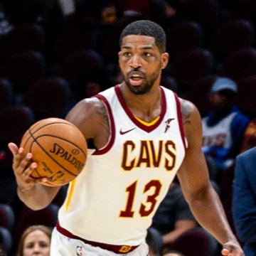 NBA champion Tristan Thompson, wearing his Cleveland Cavaliers #13 jersey, dribbles the ball during a game — the same player now championing Bitcoin to his teammates as a "digital gold" investment.