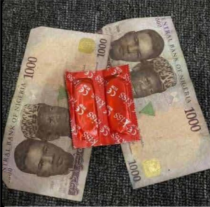 Two 1000 Naira banknotes from the Central Bank of Nigeria underneath three red 'Kings' brand candy wrappers.