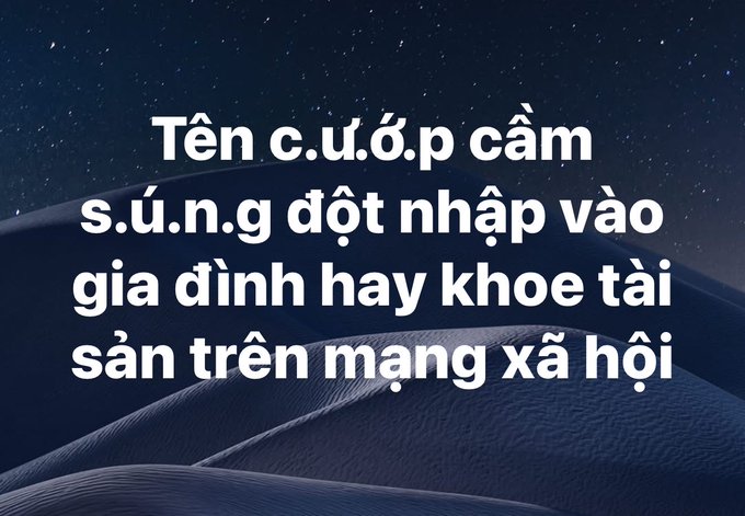 Vietnamese text with letters removed reading 'Tên c.u.ổ.c p.câm s.ú.n.g đột nhập vào gia đình hay khoe tài sản trên mạng xã hội' over a dark blue sand dunes background.