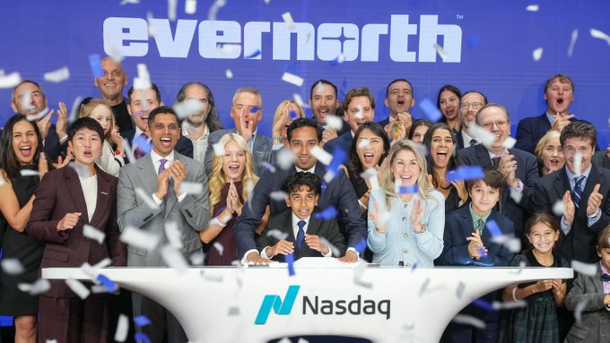 Evernorth executives celebrate their Nasdaq listing behind a podium, with confetti falling around the group and a bold "NASDAQ" digital display serving as the backdrop, celebrating $XRPN's official debut as a public digital asset treasury.