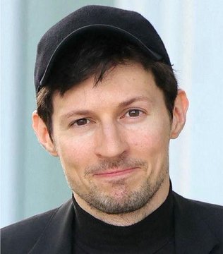 A portrait photo of a man wearing a black baseball cap and black turtleneck, smiling slightly at the camera.