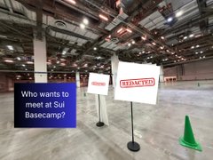 A warehouse scene with signs reading "REDACTED" and "Who wants to meet at SUI Basecamp?" standing on an empty concrete floor.