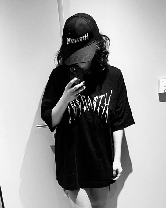 The image features a person taking a selfie with their phone, wearing a black t-shirt and a baseball cap with the word " megaeth" written on it. The photo captures the individual's face as they pose for the camera. The caption of the image reads, "What’s happening with megaeth right now honestly says more about the current state of crypto participants than it does about megaeth itself." This statement suggests that the person taking the selfie is interested in discussing or analyzing the current state and trends within the cryptocurrency world.