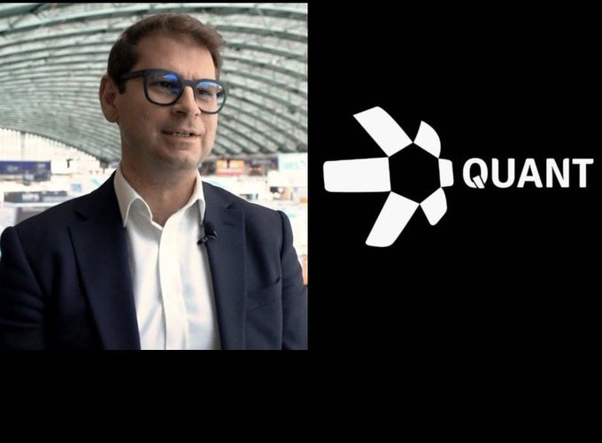 A split image showing a man with glasses in a suit on the left, and the 'QUANT' logo (a white hexagonal star design with the word QUANT) on a black background on the right.