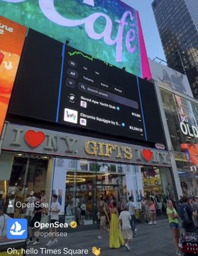 A busy Times Square scene shows the OpenSea mobile app on a giant billboard above an I ❤️ NY GIFTS storefront, featuring Bored Ape Yacht Club artwork. The post highlights the recognizable @BoredApeYC NFT displayed on the @opensea app billboard.
