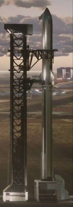 A tall, silver rocket stands vertically on a launch pad alongside a black service tower, with the ocean and other launch infrastructure visible in the background.