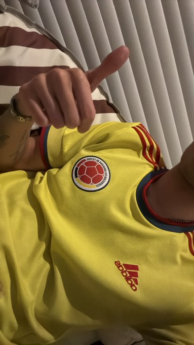 A person wearing a yellow Adidas soccer jersey with the Colombian Football Federation crest, giving a thumbs-up gesture.