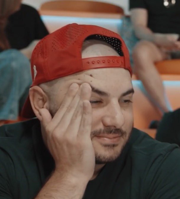 A young man wearing a red cap rubs his face with his hand, eyes closed in apparent disbelief or exasperation. The image humorously captures skepticism or an eye-roll reaction to the vague, jargon-heavy post about a "stealth AI project" involving Solana tokenization.