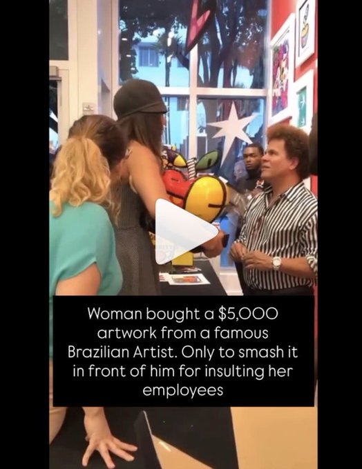 A video still showing a woman at what appears to be an art event with a man and artwork in the background, with text overlay reading: 'Woman bought a $5,000 artwork from a famous Brazilian Artist. Only to smash it in front of him for insulting her employees'.