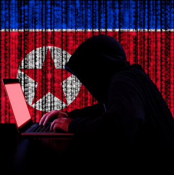 A hooded figure works on a laptop in front of a digital North Korean flag, symbolizing cyber threats, with cascading code representing hacking or data breaches—reinforcing the warning not to click suspicious links.
