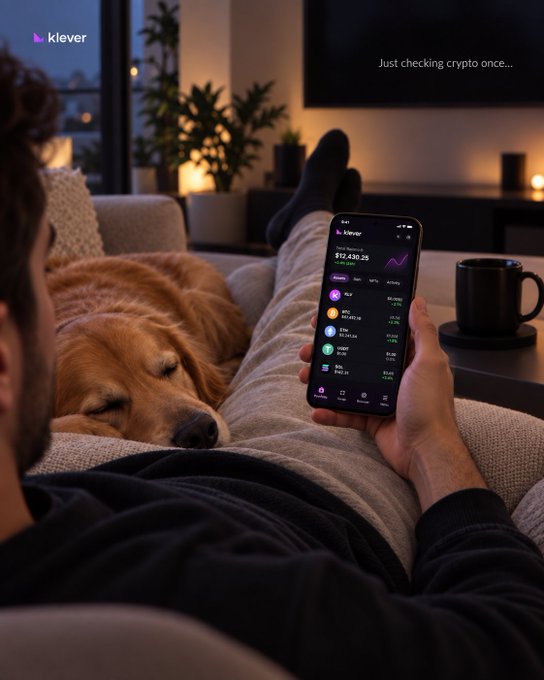 A man lounges on the couch with his sleeping golden retriever, casually checking the Klever app on his phone, where Bitcoin's total value is displayed at $12,430.26. The cozy evening scene perfectly captures the post's irony of "Sunday plans" that sneak in some crypto monitoring alongside the relaxation.