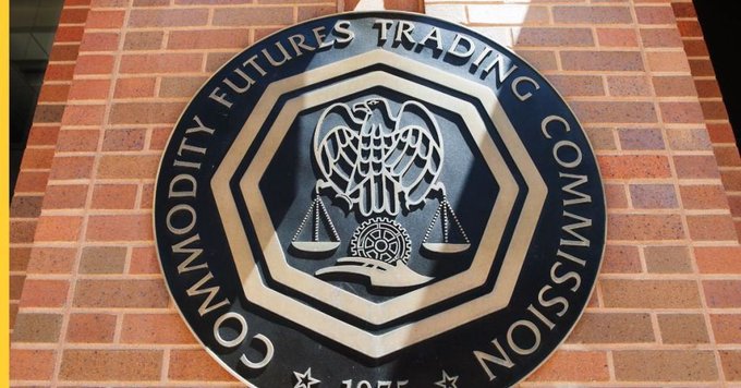The image features a circular sign with a black background, which displays the text "CFTC Approves First U.S. Regulated Bitcoin Perpetual Contract Through KALSHI Exchange". The sign is mounted on a brick wall, and there are two birds depicted in the center of the circle, symbolizing the cryptocurrency market.