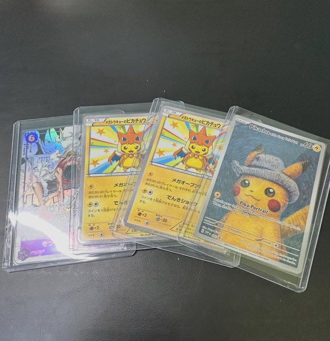 Four Pokemon trading cards in protective sleeves are displayed on a dark surface, including a Pikachu card and a Pika-Portrait card.