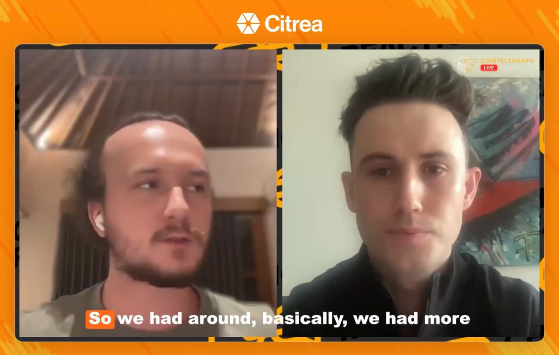 In this image, two men are shown on a video call with a laptop screen behind them displaying their faces. One man has his hair cut short and glasses on, while the other is bald with a beard and mustache. The text overlaying the image reads "So we had around,basically;we had more", which appears to be a part of an advertisement for Bitcoin capital markets. The men are positioned in front of each other, facing one another as they engage in conversation or presentation on the topic.