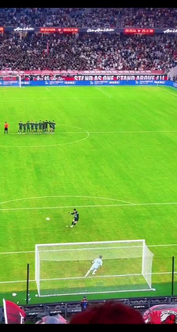 A wide stadium shot of a football/soccer penalty kick with AirPods advertising banners reading 'AirPods 远东店', '无间先锋 音乐先声', and 'AirPods STAND AS ONE STAND ABOVE ALL'.