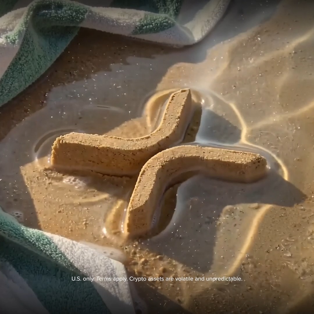 A letter "X" shaped pastry or dessert sits in creamy sauce, tying into the "Riding the XRP Summer wave" giveaway by Uphold offering $100 in XRP to five winners. The image includes the disclaimer text: "U.S. only. Terms apply. Crypto assets are volatile and unpredictable."