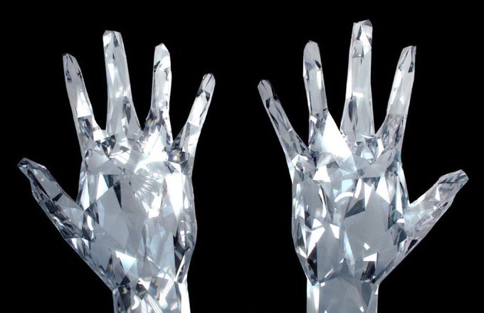 Two crystalline, faceted hands with splayed fingers, rendered to resemble diamond or glass, are positioned against a stark black background.